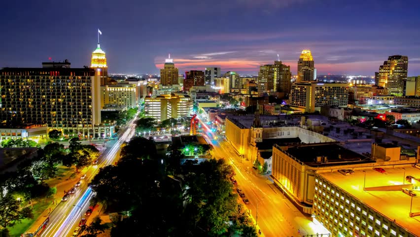 Night view of San Antonio, Texas skyline with illuminated buildings, glowing city lights, and vibrant urban cityscape atmosphere.