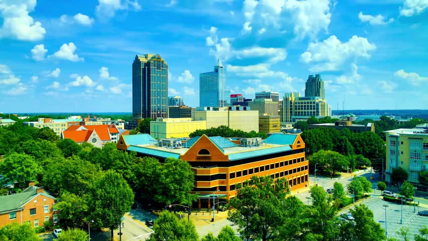 Downtown Raleigh, North Carolina skyline on a sunny day, featuring modern buildings, clear blue sky, and urban cityscape views.