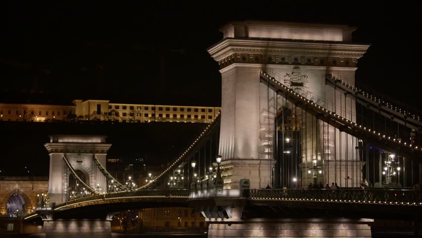 Szechenyi Chain Bridge Illuminated At Night, With Stone Towers And Suspension Cables Glowing. Budapest, Hungary. static shot