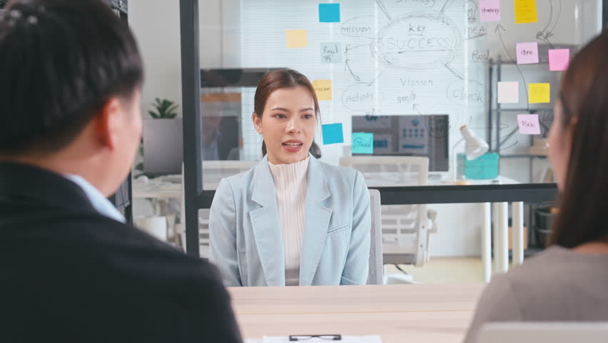 Professional Asian colleagues shaking hands after a successful job interview in a modern office. A scene of career growth, recruitment success, partnership, and new beginnings in business
