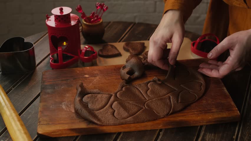 Preparing sweet food for St Valentines day. Person making heart shaped cookies