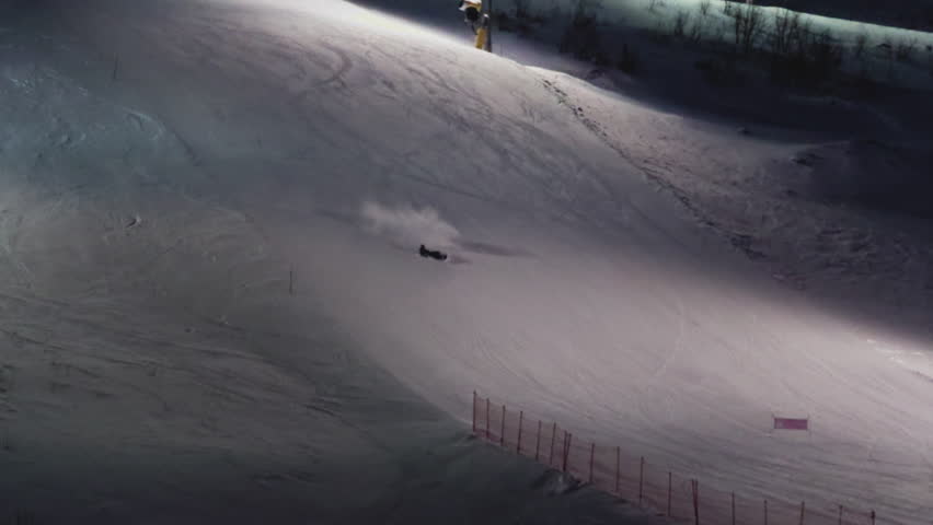 Professional snowboarder falls and rolls down, riding and falling on a ski slope. Mountain accident. Male beginner crashes in the Snow, Freestyle. Ski resort at night.
