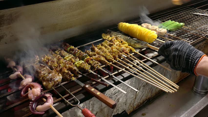 late-night food stall grilling lamb skewers and lamb chops and squid and potato tornado and other delicacies