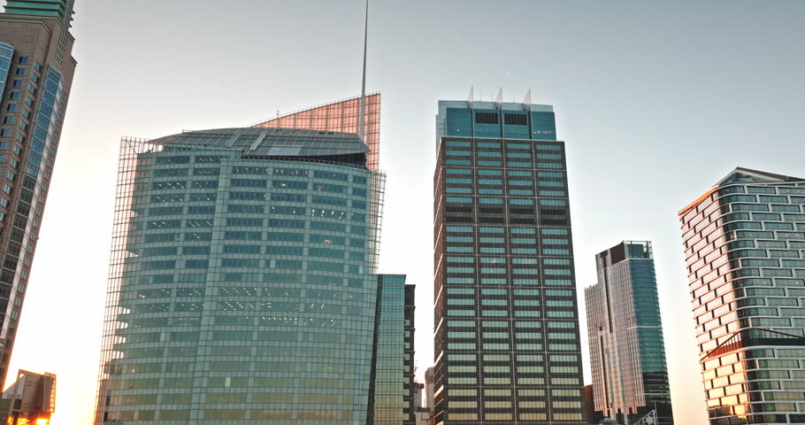 Sydney skyscrapers in central business district reflecting warm sunset light, showcasing modern architecture and urban development against clear sky, symbolizing business and finance. Aerial panorama