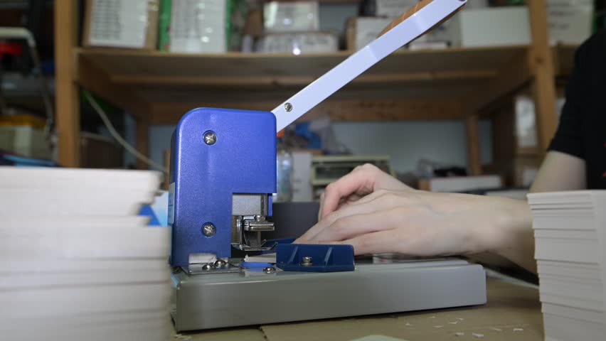 The process of cutting corners of printed products with a mechanical machine in the production room of the printing house