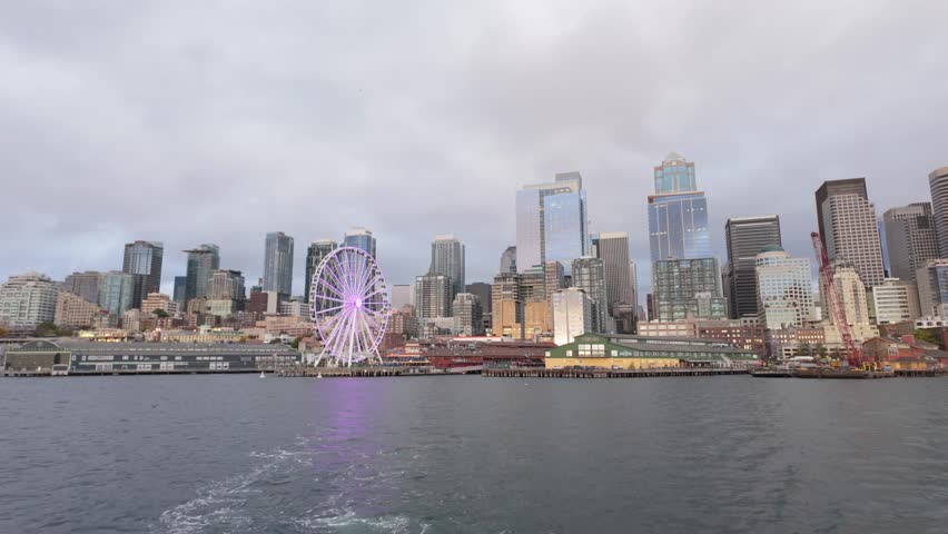 Gimbal wide shot of downtown Seattle as seen from a moving boat on the Salish Sea during early evening in Washington. 4K
