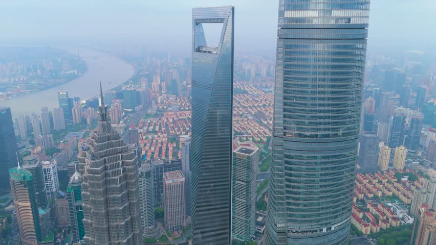 Aerial shot of the Shanghai World Financial Center, Shanghai Tower, and other massive modern skyscrapers in the Lujiazui financial district, Shanghai, China.