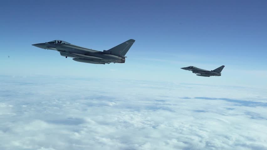 Military Jet Fighters Flying in Formation Over the Clouds