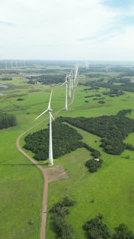 Wind farm turbines producing renewable energy, aerial view over green countryside