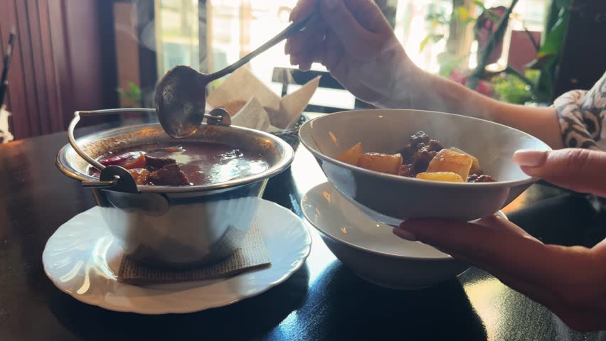 Steaming freshly cooked delicious goulash soup is served in bowls. Hungarian cuisine concept. High quality 4k footage
