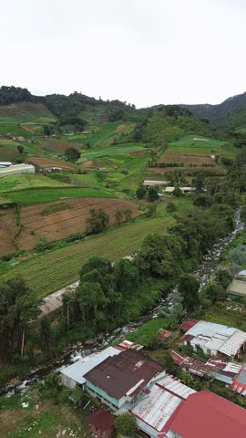 A rural area with a river running through it and a few houses
