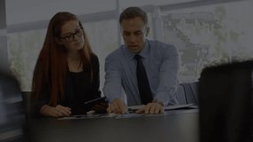 Animation of financial data processing over diverse man and woman discussing over computer at office. Global economy and business technology concept - Powered by Shutterstock - Get 15% off with code: PIKWIZARD15