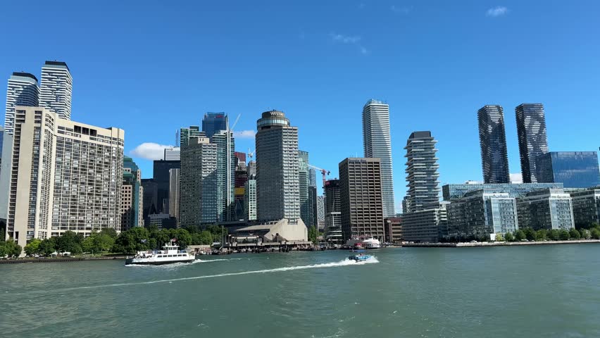 Beautiful Ferry View Toward Downtown Toronto With Modern Skyscrapers Reflecting Sunlight As Boats And Yachts Move Across The Calm Blue Waters Of Lake Ontario On A Clear Bright Summer Day In Canada