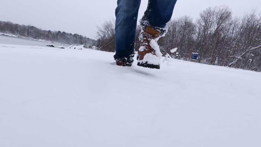 A Man In Winter Shoes Walks Along Snowy Trails In A Park During Cold Season. Winter Hiking And Wellness Walk In Nova Scotia, Canada, With Calm Nature And Outdoor Recreation.