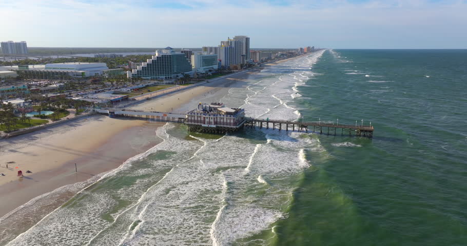 Main Street Pier with restaurant in Daytona Beach, Florida, offering ocean views and direct access to beachside hotels, condos, and tourist amenities.