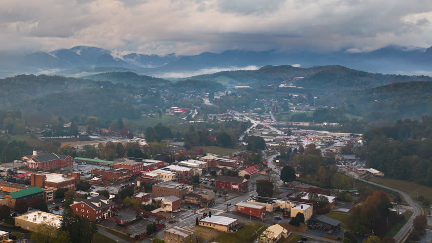 Aerial landscape of Franklin town center at dusk with illuminated tourist streets and Great Smoky Mountains scenery. North Carolina travel destination.