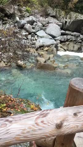 Clear turquoise river flowing through rocks and forest landscape in Tuscany.