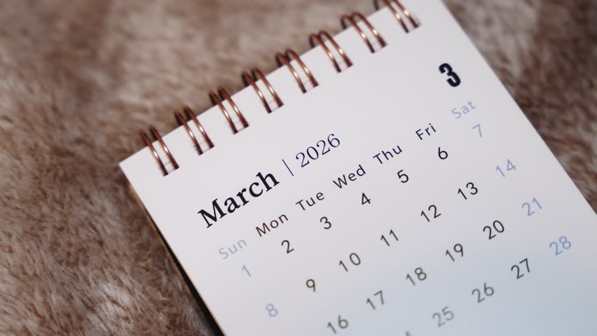 Close-up of March 2026 calendar page with finger indicating date, future planning and personal organization concept.