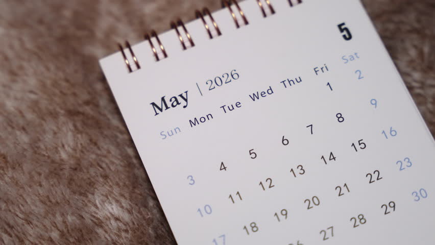 Close-up of May 2026 calendar page with finger indicating selected date, planning and productivity concept.