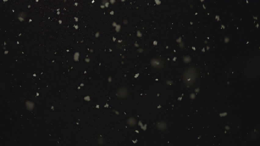 Snowflakes drifting in darkness on a calm winter night