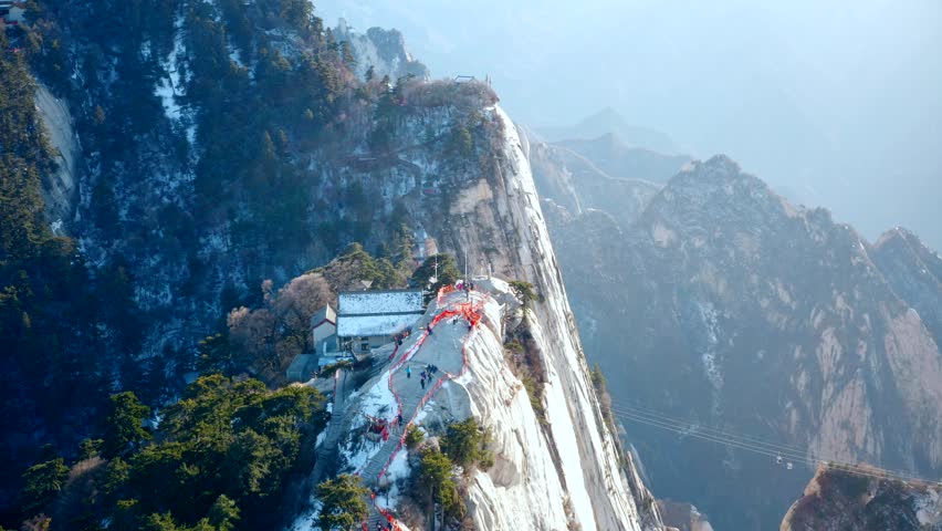 This 4K aerial time-lapse video captures the breathtaking natural beauty of West Peak of Huashan (West Yue) in Shaanxi, China, showcasing the spectacular sea of clouds swirling around the steep granite peaks and majestic mountain ridges. It presents the iconic misty cloud scenery and grand mountain landscape of this famous Chinese sacred mountain, perfect for travel promotion and nature-themed content creation.