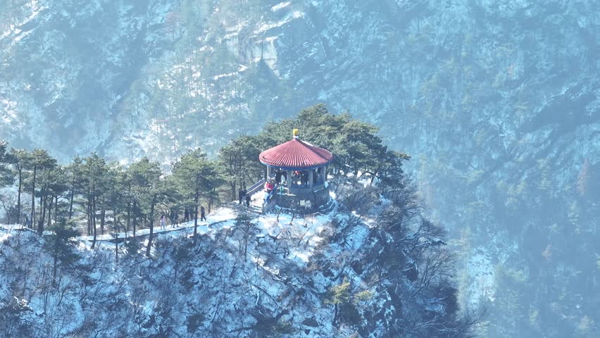 This breathtaking aerial time-lapse captures the ever-changing beauty of Mount Lu, where dramatic sea of clouds engulfs lush peaks, ancient pines stand draped in winter snow, and sunlight pierces through mist to reveal a landscape of serene power and poetic tranquility.