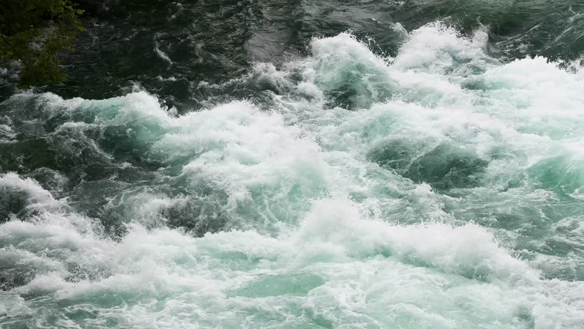 Raging river rapids with powerful turquoise water and white foam