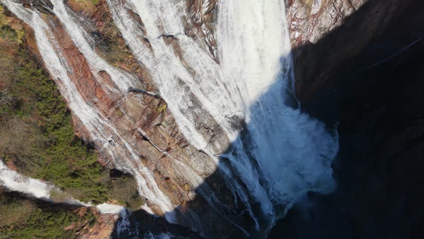 Ezaro Waterfall Flowing Over Steep Rock Face Cliffs In Galicia, Spain. Aerial Ascending Shot