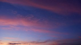 A tranquil sunrise sky timelapse video with soft pink and purple clouds drifting across a deep blue morning sky, revealing gentle cloud layers and the calm, luminous transition from night to dawn. - Powered by Shutterstock - Get 15% off with code: PIKWIZARD15