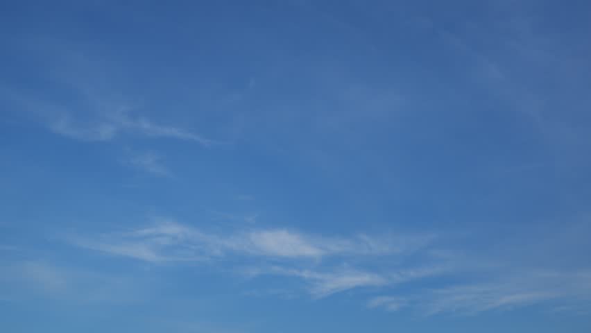 A calm blue sky timelapse video with thin, wispy clouds gently flowing across a vast clear atmosphere, emphasizing smooth cloud motion, openness, and the peaceful beauty of a serene daytime sky.
