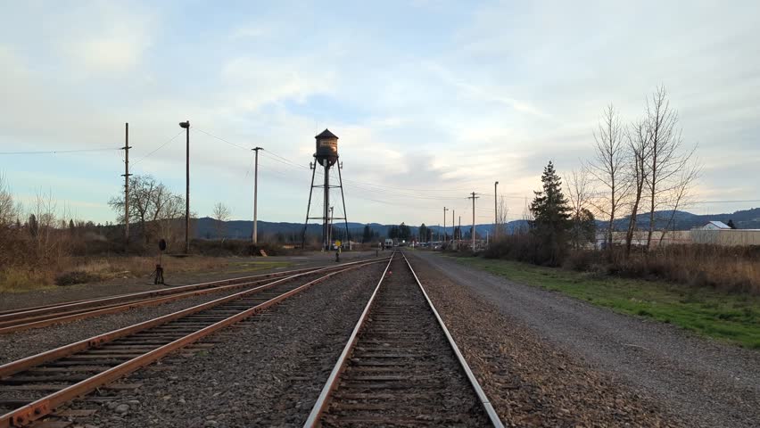 Railroad tracks at sunset during winter, changing perspective from high to low.