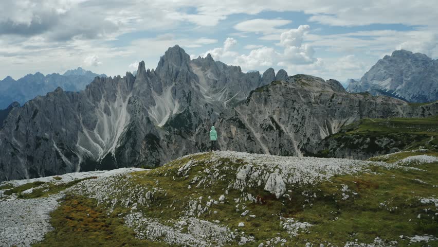 Hiker trekking in the Dolomites mountains, surrounded by dramatic peaks, showcasing adventure, outdoor exploration, nature, and active lifestyle.