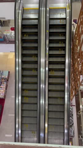 Symmetric Empty Moving Escalators in a Modern Shopping Mall or Bookstore View from High Angle