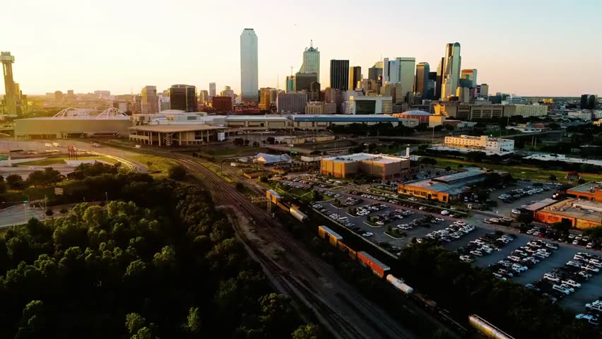 Dallas, Texas skyline at sunset with a colorful sky and city lights, capturing vibrant urban energy and iconic downtown architecture.