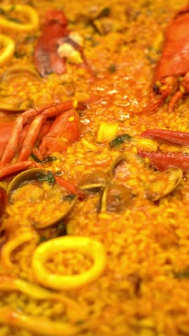 A plate of food with a yellow sauce and a lot of red shrimp