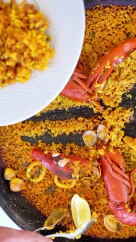 A plate of food with a spoon being used to scoop up some food