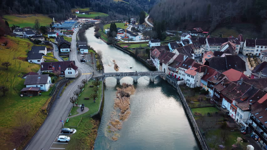 Aerial: Saint-Ursanne 18th-century St-Jean Bridge during the day in Clos du Doubs, canton of Jura, Switzerland, push in drone shot