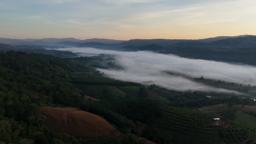 Drone video showing fog on mountaintops in the morning.