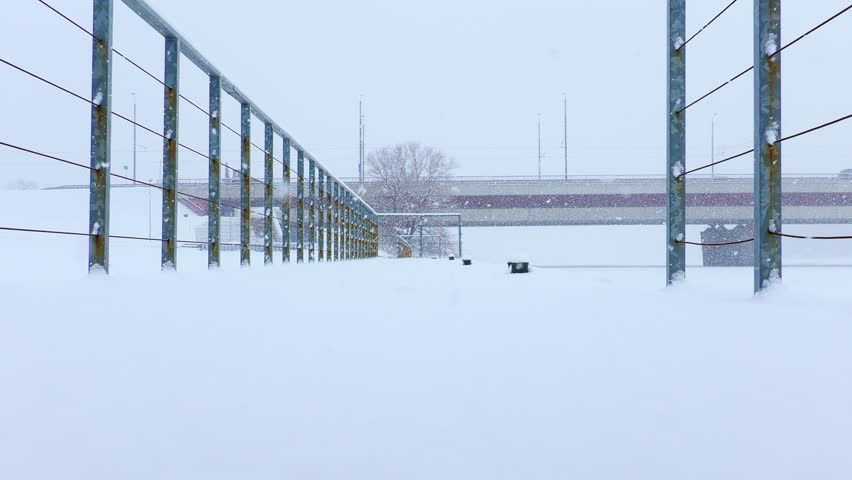 Slow motion steps through deep snow as winter storm surrounds Riga walkway