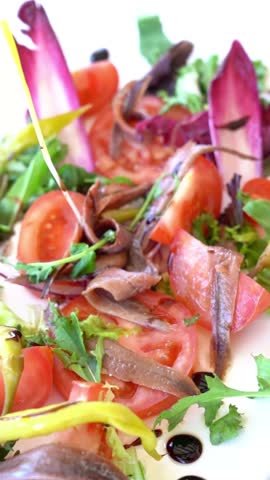 A salad with tomatoes, lettuce, and other vegetables
