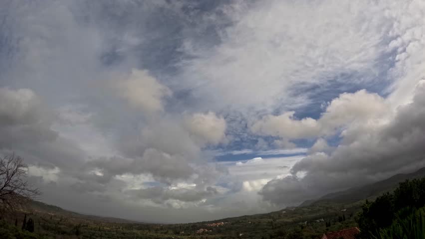 4K Time Lapse of Dramatic White Clouds Moving Fast Over Green Rural Mountain Landscape, Stormy Weather Clearing to Blue Sky, Scenic Nature Wide Angle Timelapse