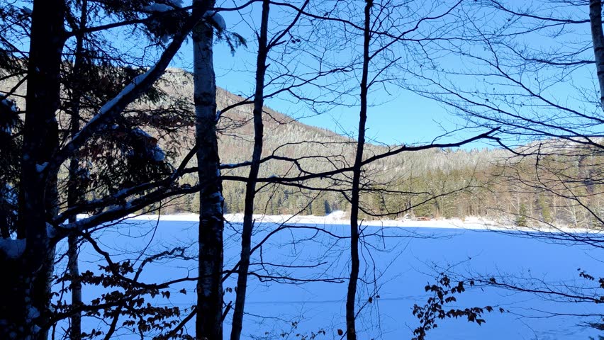 Walking past frozen winter lake in a volcano crate.
