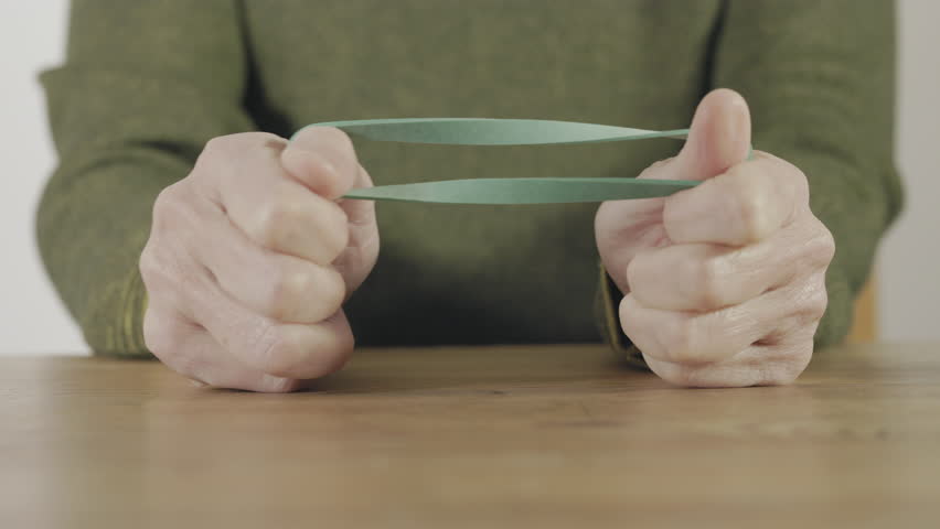 A green elastic rubber band stretched to show the tension and elasticity of the material