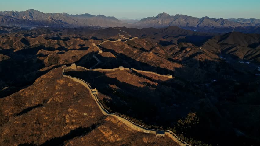 Aerial view of The Great Wall winding its way through the rugged, mountainous terrain, a testament to ancient engineering, Huairou District, Beijing, China.