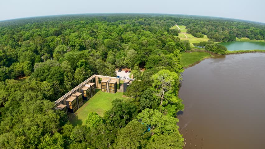 Drone footage shows a stone ruin or old structure beside a wide river and green marshland at Middleton Place Plantation in South Carolina, capturing the relationship between historic architecture and
