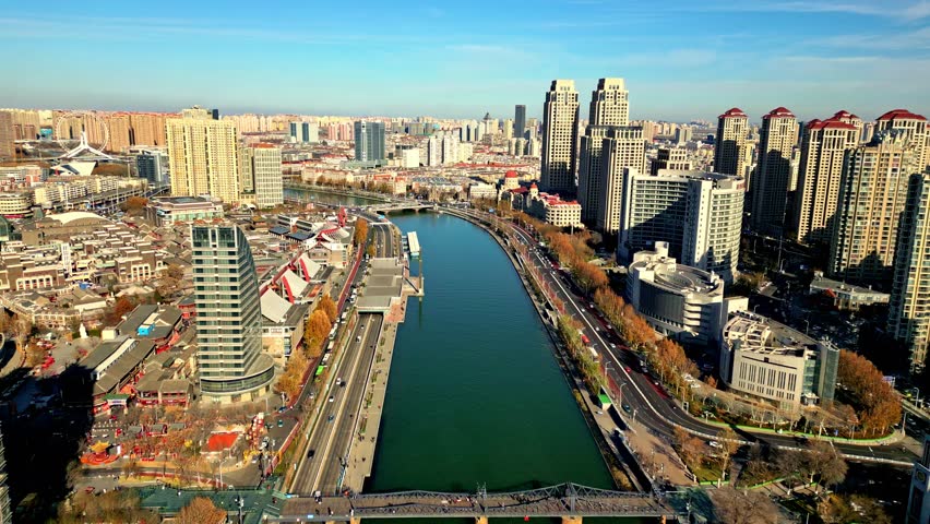 Aerial view of bridges, buildings, and the Hai River contrasting with the urban landscape, creating a dynamic composition, Tianjin, Tianjin, China.