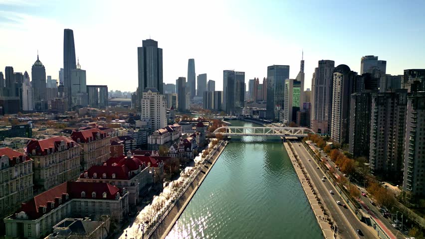 Aerial view of the Hai River flowing through the city with bridges and buildings showcasing a mix of modern and traditional architecture, Tianjin, Tianjin, China.