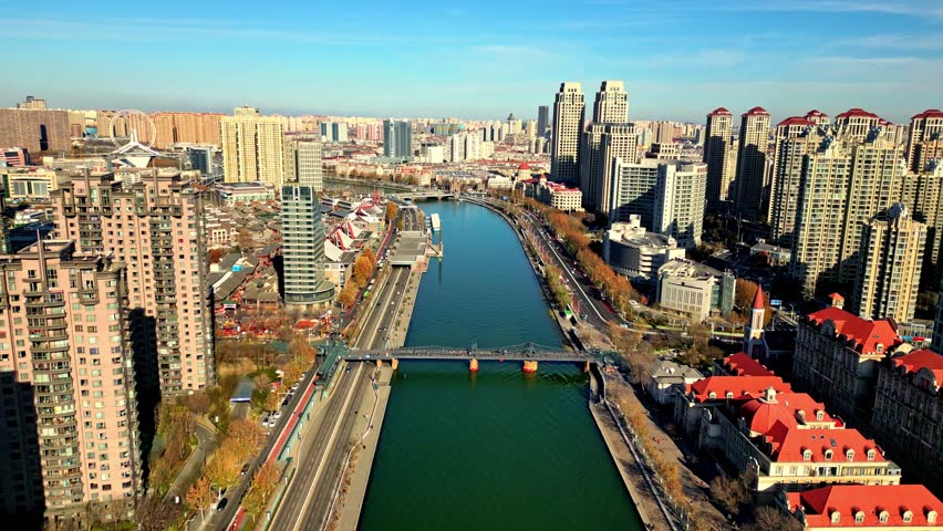 Aerial view of the Haihe River winding through the urban landscape, contrasting with the towering skyscrapers, Tianjin, Tianjin, China.