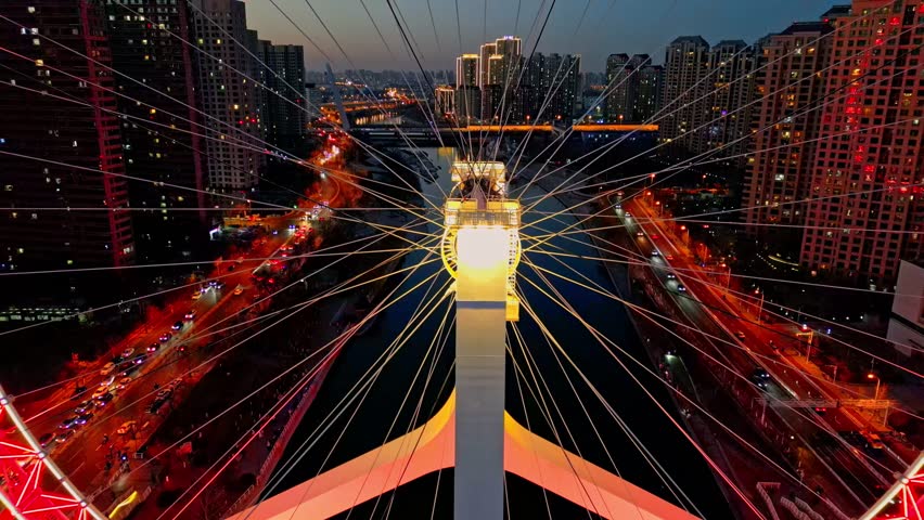 Aerial view of the radiant red Tianjin Eye Ferris Wheel against the dark cityscape, a striking contrast of modern architecture, Tianjin, Tianjin, China.