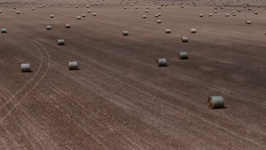 Wide drone view showing hay bales spread across vast Kansas countryside